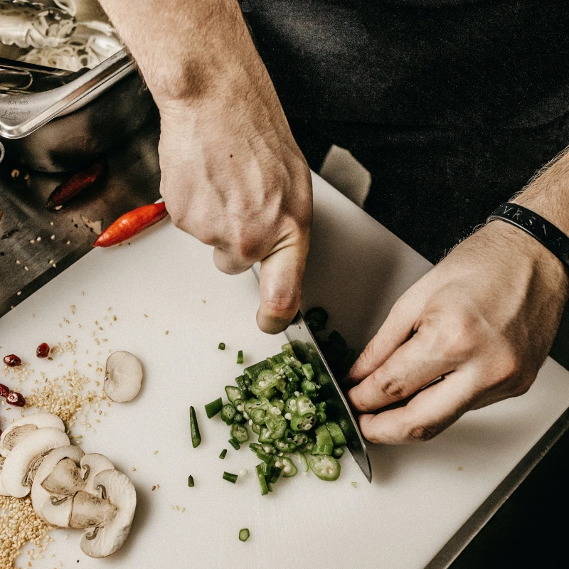 Chef eminçant des champignons pour une recette de cuisine