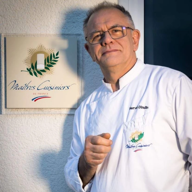 Chef de Cuisine du restaurant gastronomique, le Silène, Hervé Dindin, devant l'écriteau Maître Cuisinier de France