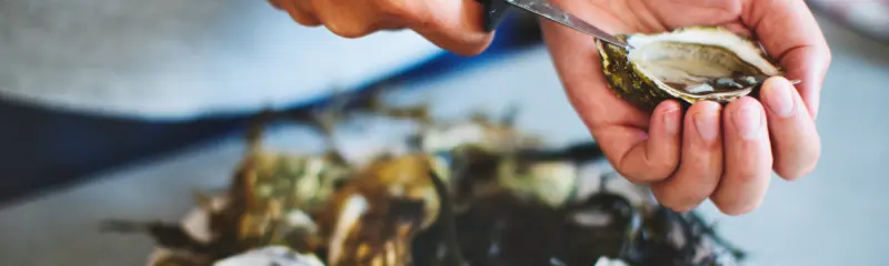 Cuisiinier qui ouvre des huîtres