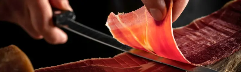 Cuisinier qui découpe du jambon